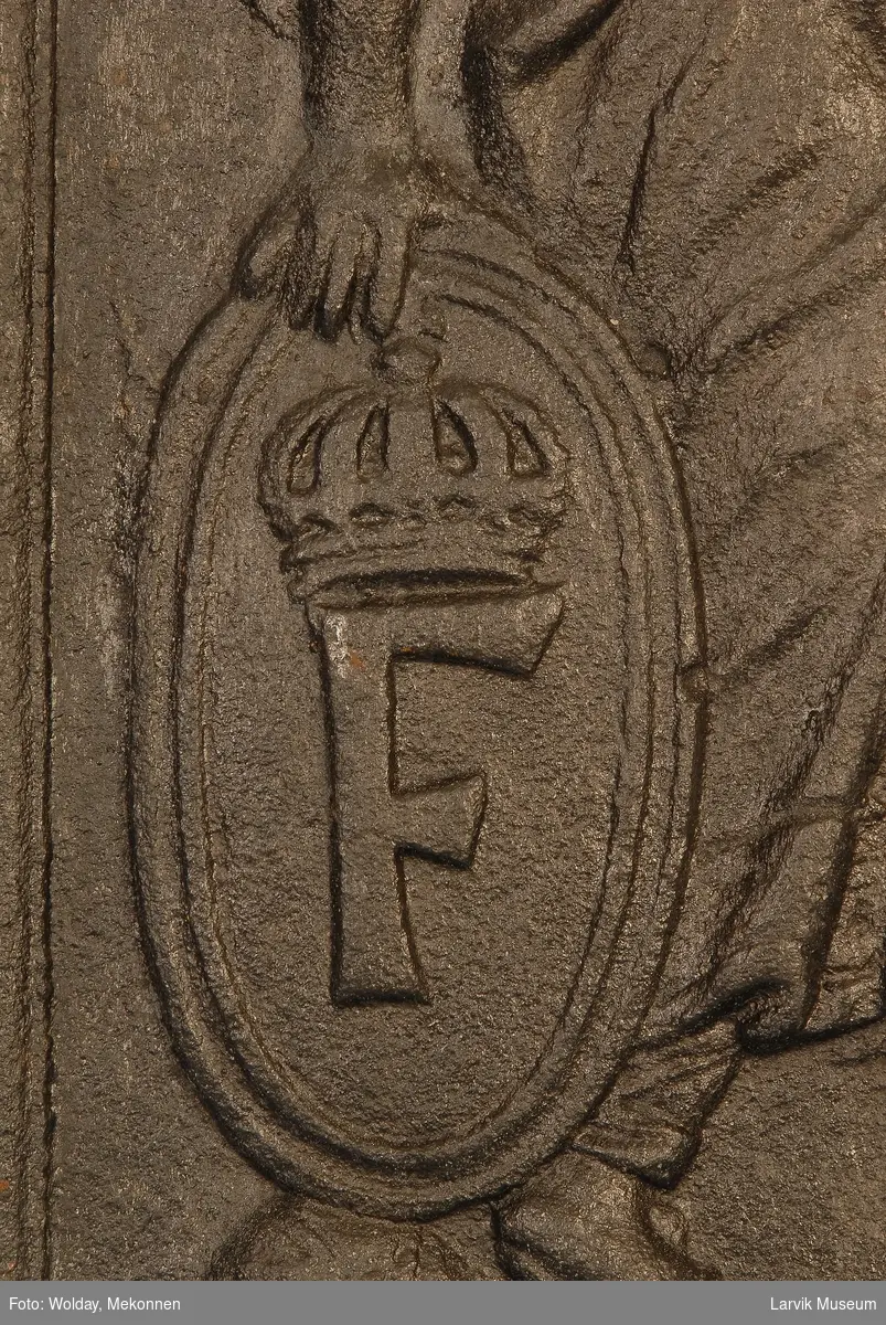 Minerva gående mot høyre med spyd i sin venstre hånd og ovalt skjold med kronet F i høyre hånd