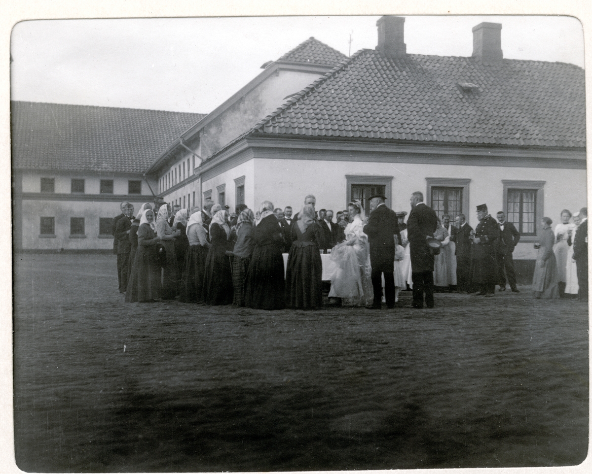 Bryllupsfeiring på Bogstad gård. Brudeparet Nini og Westye Egeberg, med ryggen til, møter de ansatte på gårdsplassen. Fotografert 17.09.1904.