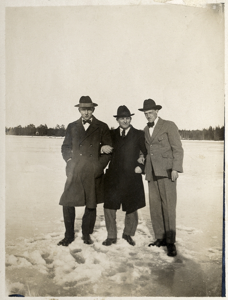 Tre unga män i rock och hatt, ute på sjöisen en solig vinterdag.
Till höger Gösta Håkansson (1902-1981).