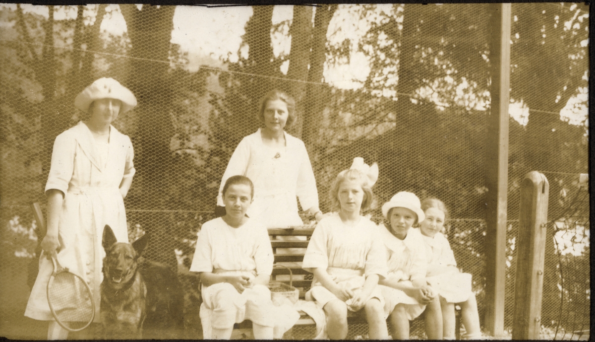 Familiebilde fra Bogstad gård. Fra venstre Mimi Egeberg med tennisracket og hunden "Kekk", Lucy Egeberg, stående Johanne Løvenskiold, Harriet Wedel Jarlsberg, Nini ? og Karen Egeberg. Fotografert 1922.