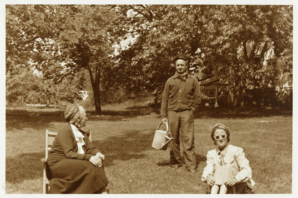 Nini Egeberg med datter og svigersønn Mimi og Rolf Grieg Halvorsen i hagen, trolig på landstedet Dannevigen i Grimstad. Antagelig fotografert 1942.