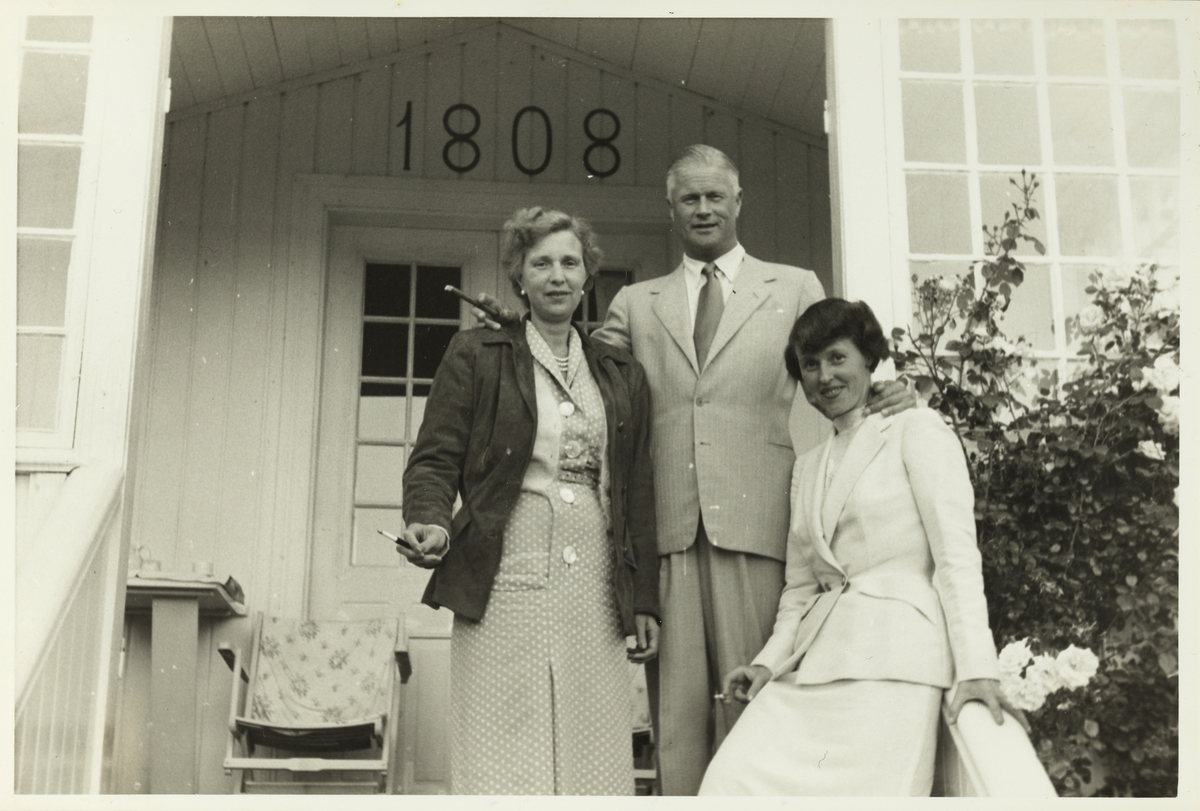 Evelyn og Herman Løvenskiold står sammen med fru Thømte foran veranda på landstedet Dannevigen i Homborsund. Årstallet 1808 står over verandadøren. Fotografert 1953.