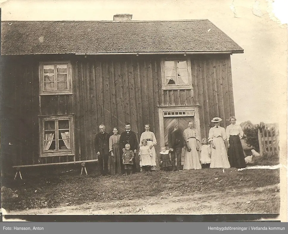 Gruppfotografi från norra sidan av Fröset Västergård, 1908 med den gamla verandan. 
Fröderyds Hembygdsförening