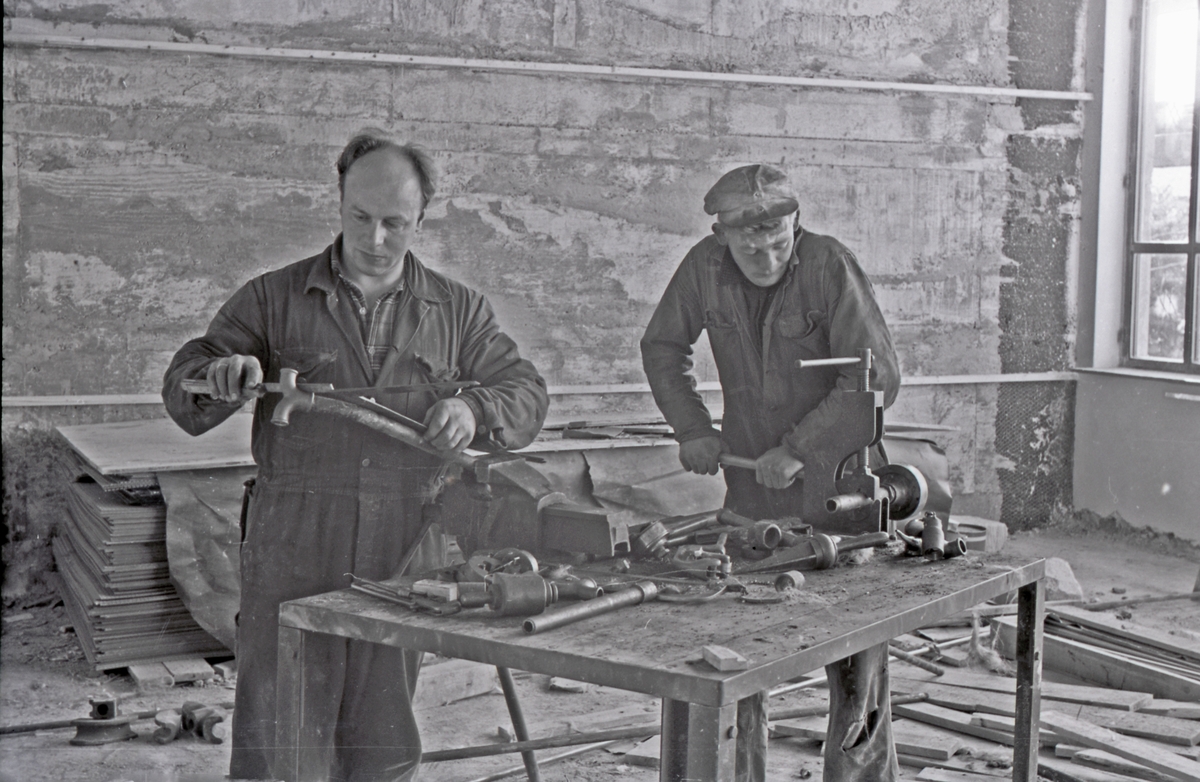 Arbeid med installasjon av sentraloppvarmingsopplegg i klasserom under renoveringen av Hauge skole, ca. 1955.