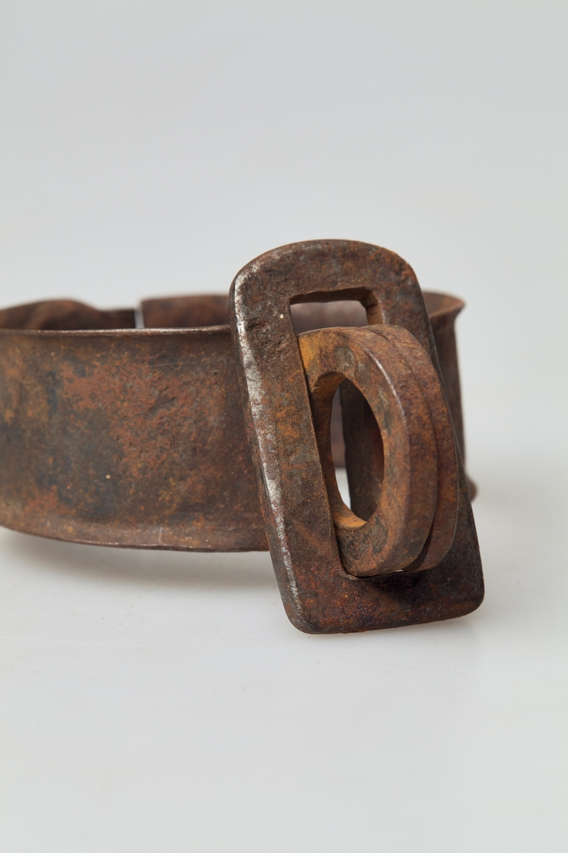 Et par håndjern (a-b). Jernringen består av to halvringer som er festet sammen i en gjenge, i andre enden en jernplate med hull for lås.