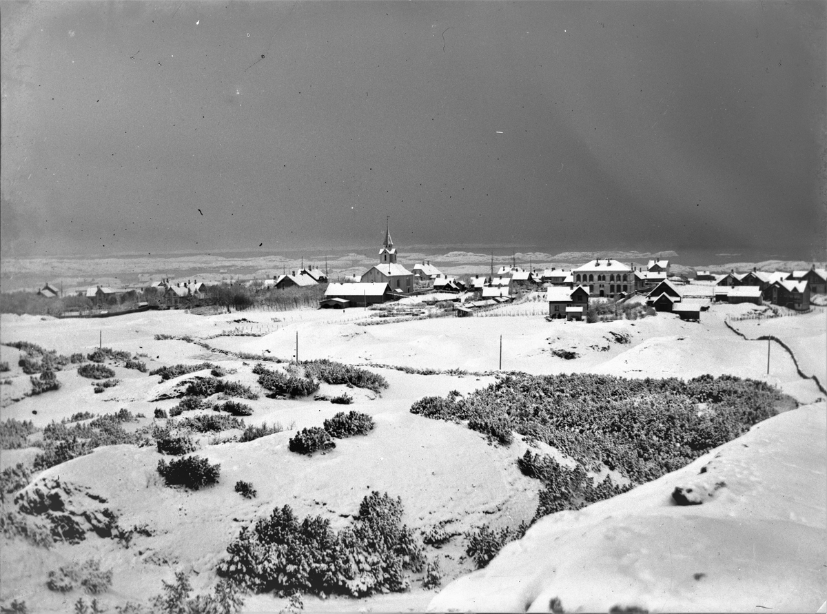 Parti av Haugesund i vinterdrakt med snø. Hauge. Skåre kirke og Hauge skole midt i bildet. Spredt bebyggelse.