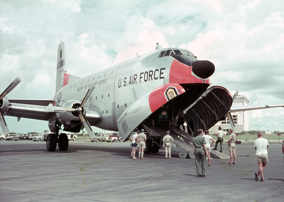 Lastning av amerikanskt transportflygplan Douglas C-124 Globemaster II på flygbasen i Kamina under FN-tjänst, 1962-1963. FN-personal står vid flygplanet. Vy framifrån.