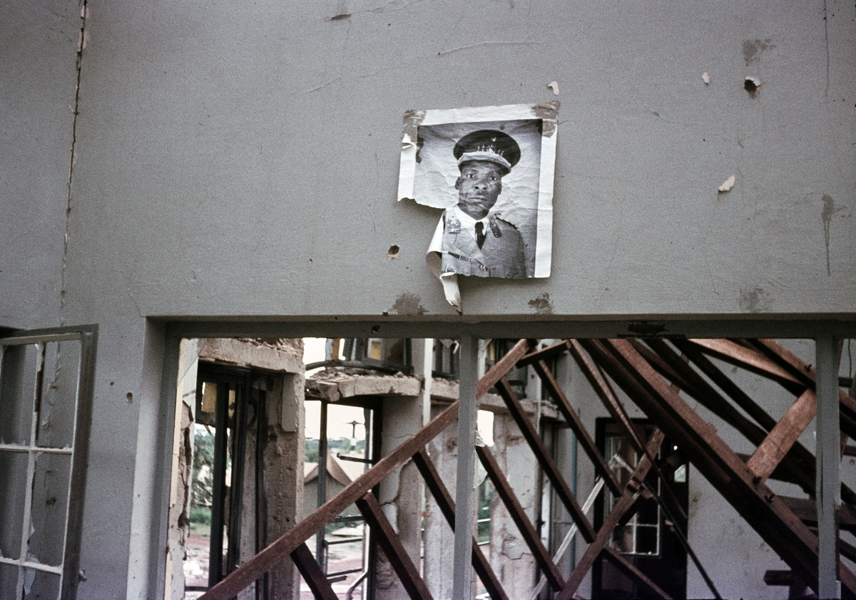 Interiör av sönderskjuten flygstationsbyggnad i Kolwezi efter attacker under Kongokrisen 1962. En porträttbild av en militär har förstörts.