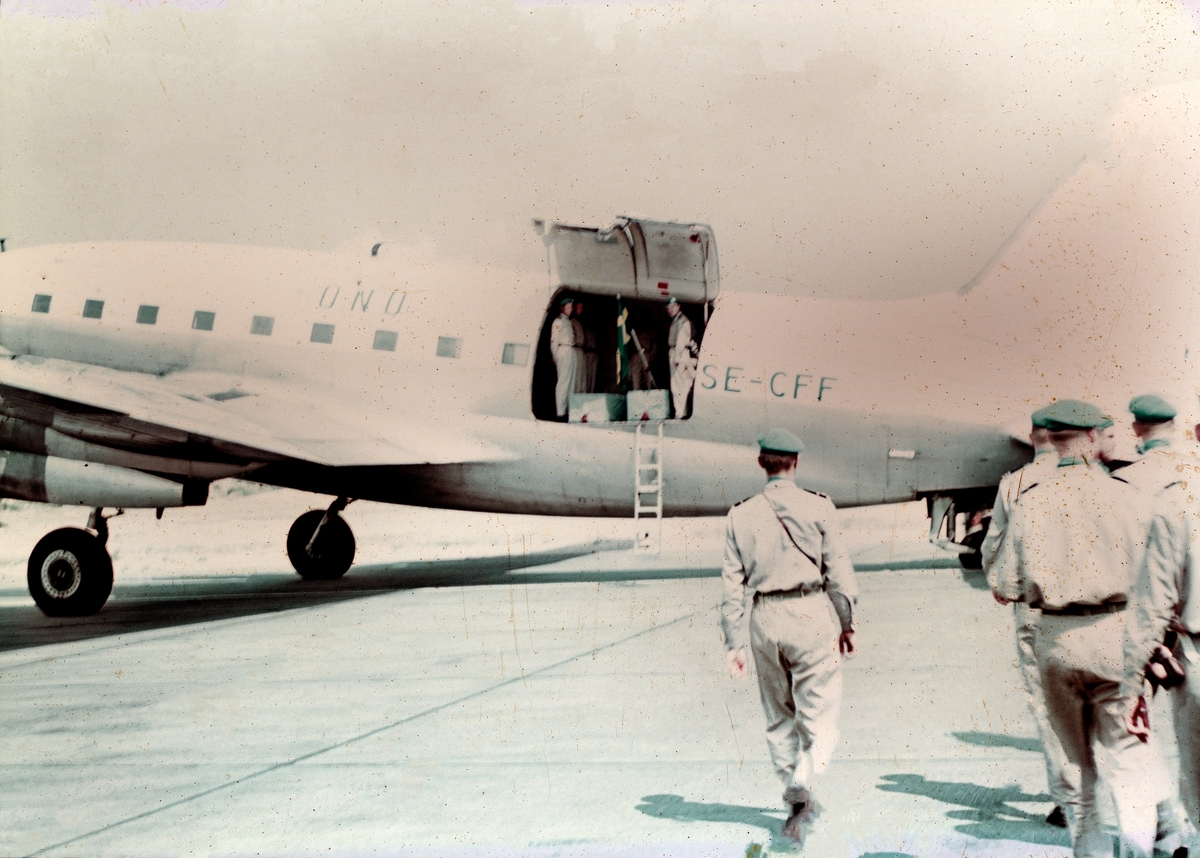 Förberedelse inför hemtransport av avlidna svenska flygtekniker ur FN-styrkan F 22 under Kongokrisen, 1962. Kistor lastade i FN-märkt transportflygplan Curtiss C-46, med civilregistrering SE-CFF, tillhörande Transair.