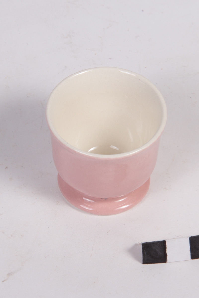 Rosa eggeglass av glasert keramikk.
