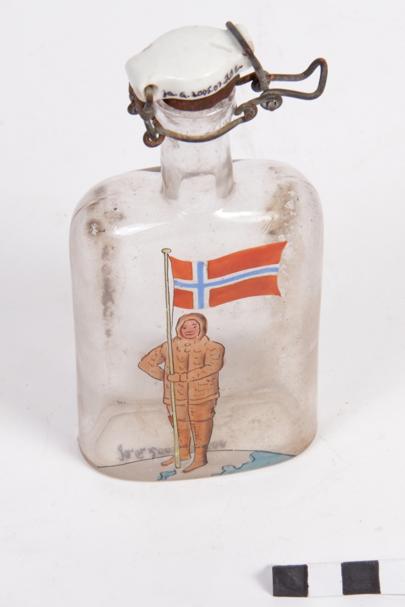 Liten flat glasflaske med Hengsla kork. (Patentkork)
Motiv av norsk polfarar med flag er malt på framsida.