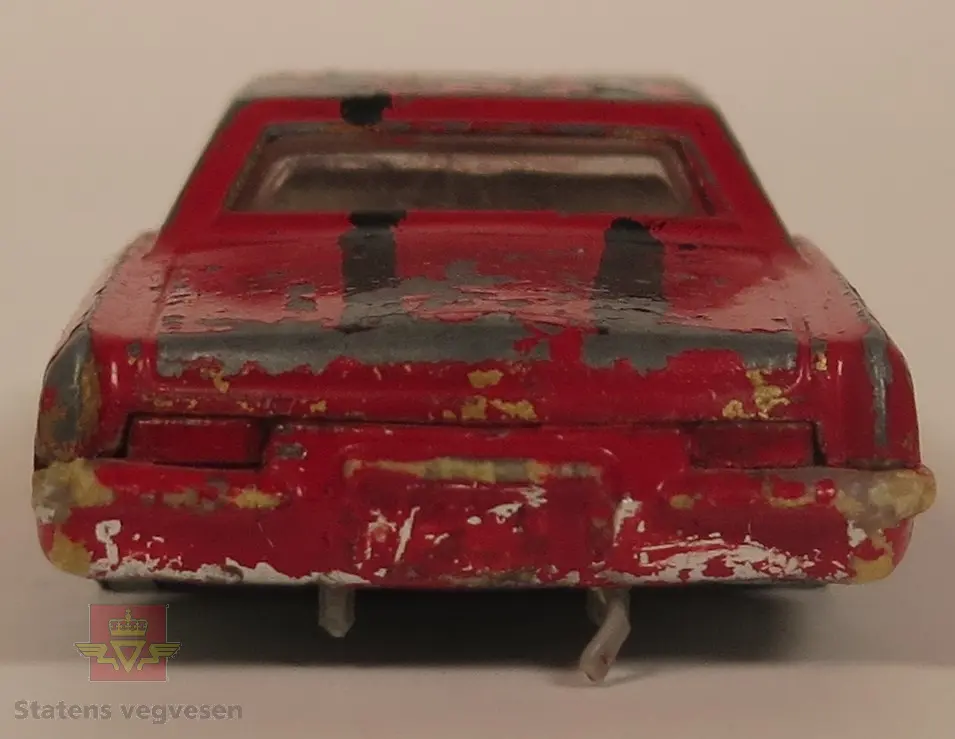 Hovedsakelig rød og sekundært svart Buick modell. Den er laget av metall og mangler alle dekkene. Skala 1:57.