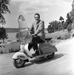 Finn-Erik Vinje på scooter, 1950-tallet.