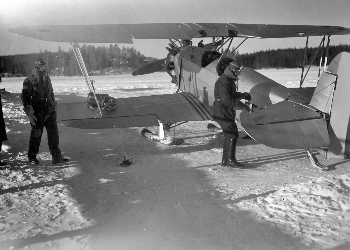 Förberedelse inför flygning av flygplan Sk 10, vintertid. Två flygare på väg till flygplanet. Cirka 1932-1939.