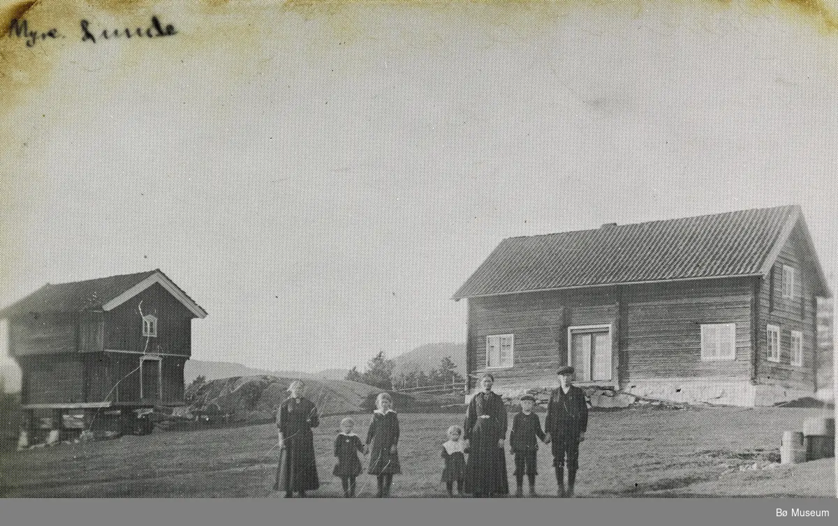 Biletet er teke på Myhre i Nordbygda, Lunde i 1915. F.v Bergit Aarmot (tenar)f. 1894, så er det Kari, Ingeborg, Anne,, mor Signe, Hans og Torstein Myhre.  Far Gunnar var fråverande då biletet vart tatt.