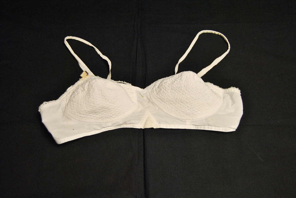 Brystholder med to kopper med blonder på, justerbare stropper over skuldre og feste med hekte bak.