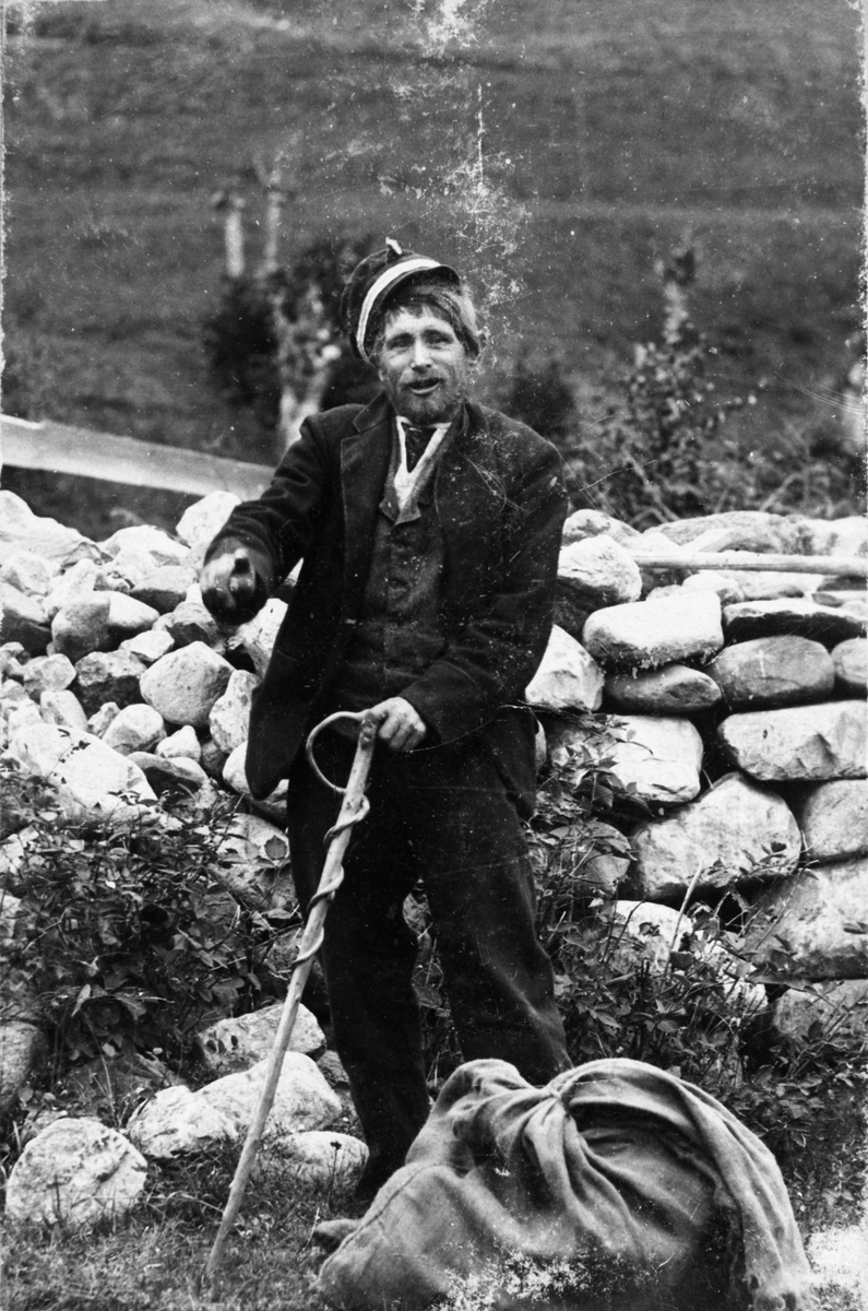 Fotosamling etter Øystein O. Kaasa. (1877-1923). Portrett av mann med stokk og sekk.