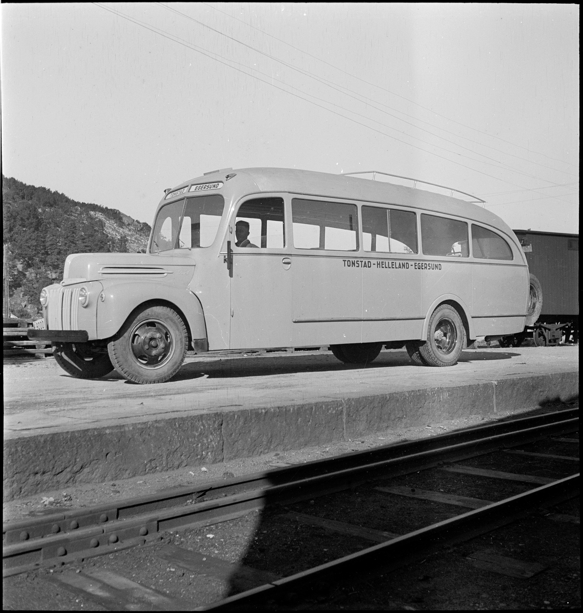 En buss av merket "Ford" ved jernbaneskinner i Egersund. Bussen gikk i ruta Tonstad-Helleland-Egersund.