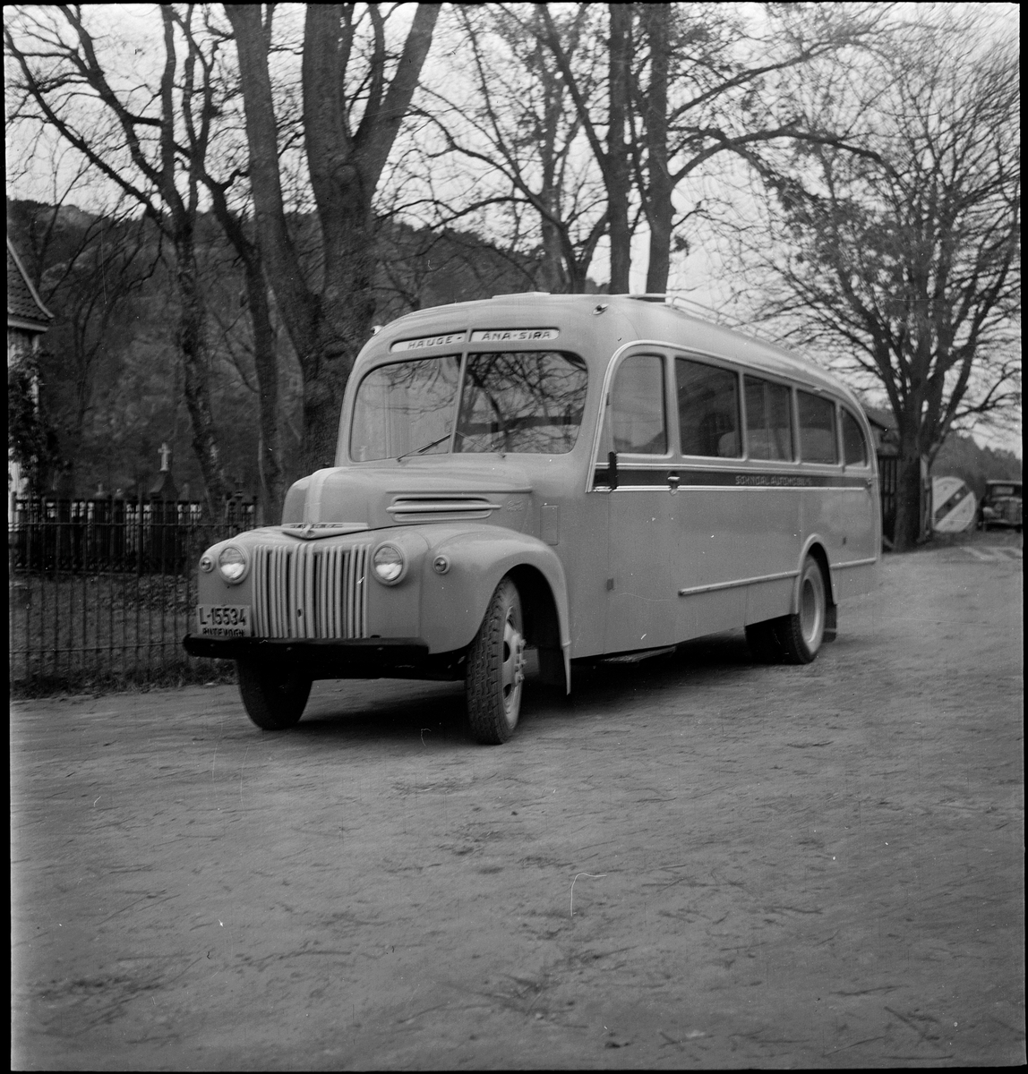 En buss av merket "Ford" fra "Sokndal Automobil A/S" på gamle Egersund rutebilstasjon. Egersund kirke er i bakgrunnen. Bussen gikk i ruta Hauge-Åna-Sira.