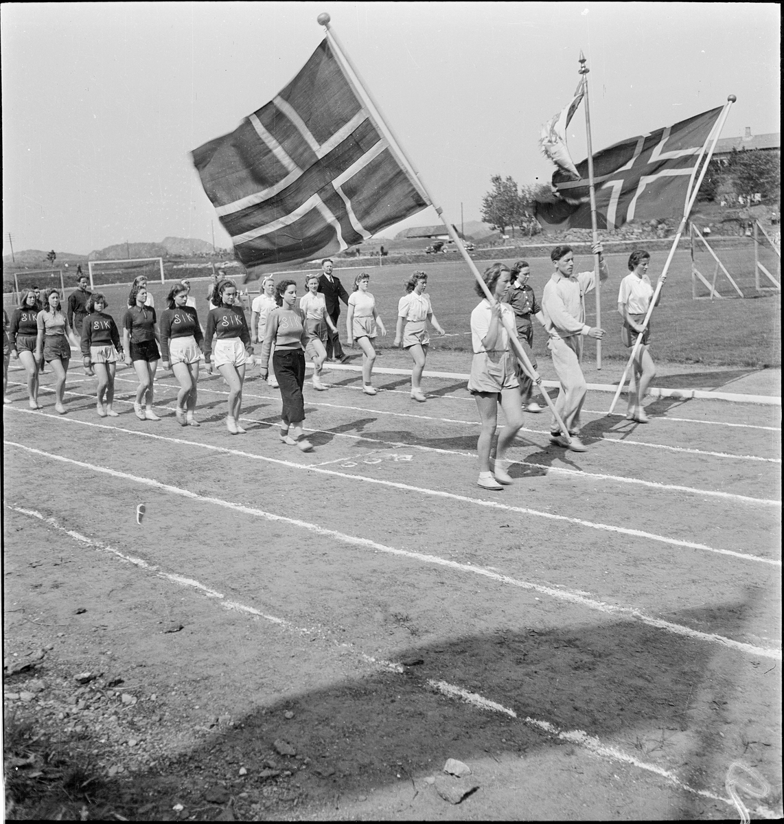 Idrettsutøvere på vei inn på idrettsmarka i Egersund. Det er utøvere fra Stavanger IK, Skjalg IL og Egersund IK.