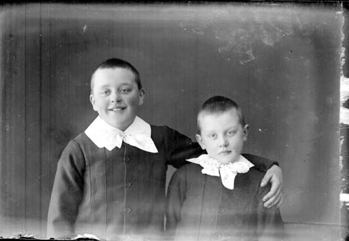 Bröstbild med två pojkar, med vita kragar.