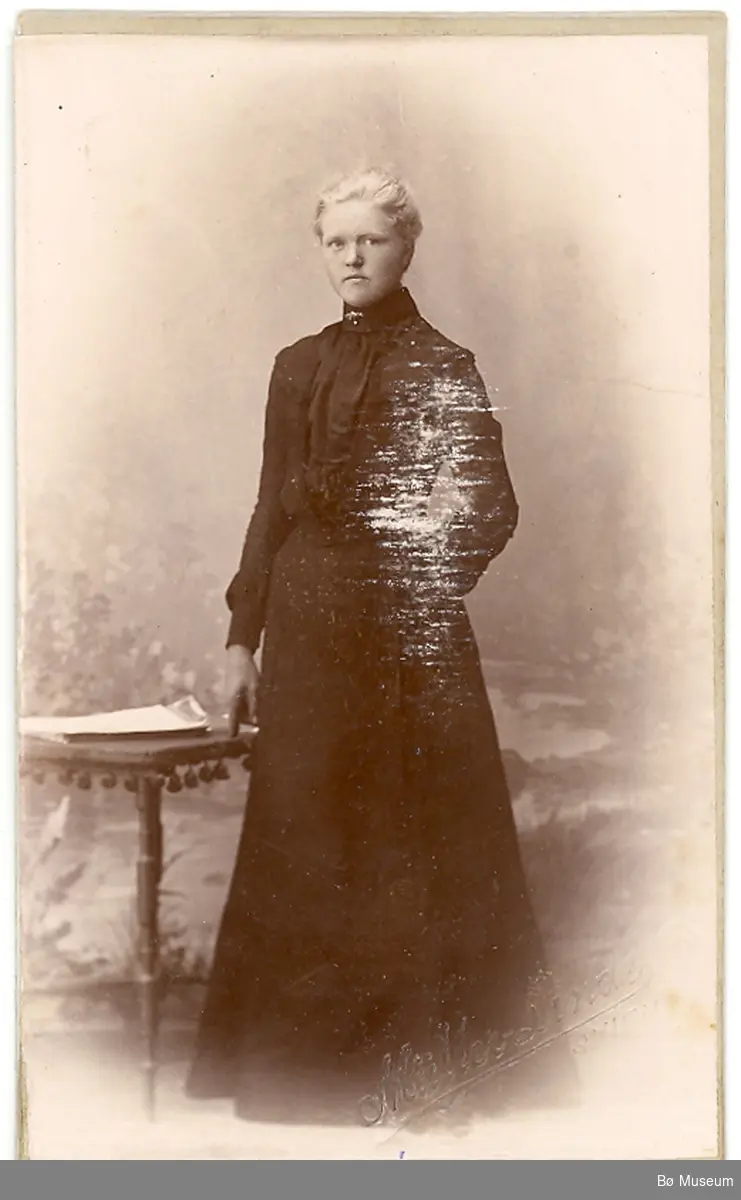 Yngre kvinne i kjole i fotoatelier; Ingeborg O. Folkestad frå Skien
