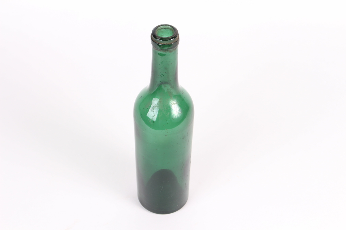 Grøn glasflaske til oppbevaring av drikke, utan kork.