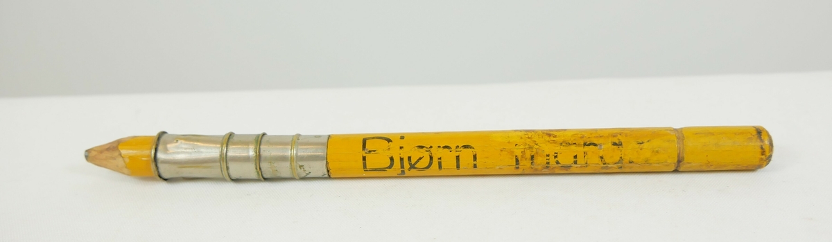 Rund gul blyant som har blitt spisset i den ene enden. Et metallbeslag nedenfor blyantspissen. 

Rund blå blyant som er spisset i den ene enden

Rund svart fyllepenn med lokk