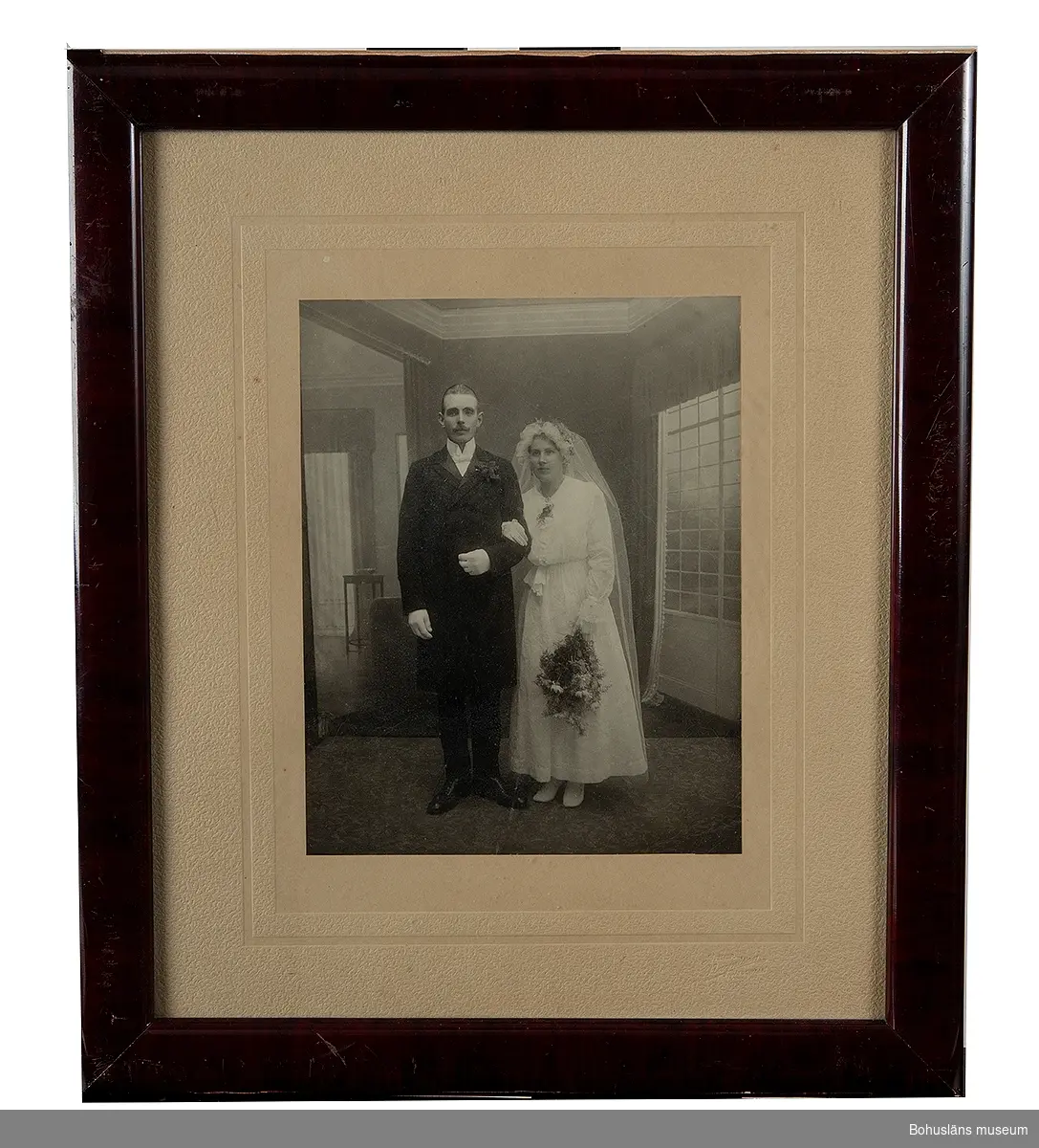 Bröllopsfotografi inramat med slät mahognyram och glas.

Sammanhör med UM015462-UM015505. Se bilaga.