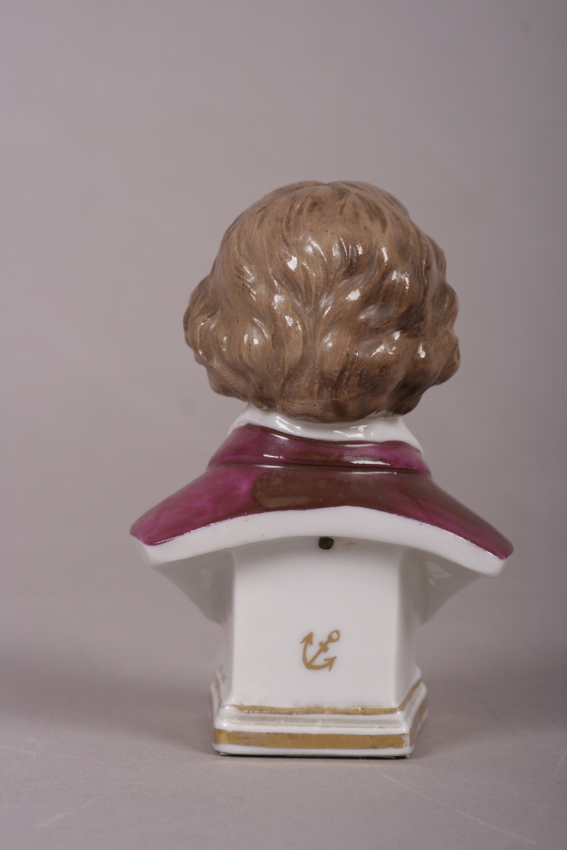 Byste i malt porselen. Forestiller Ludwig van Beetohven med grå-brunt hår ikledd rosa jakke.