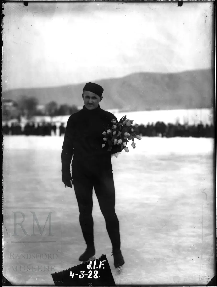 Skøyteløperen Oscar Mathisen på stevne i Jevnaker, holder en blomsterbukett.