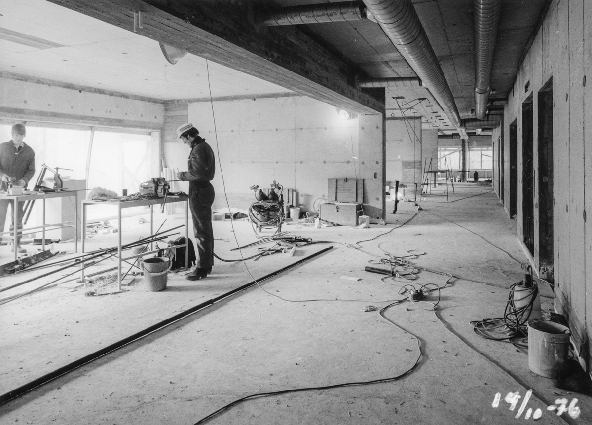 Bygginga av Odda sjukeheim i 1975-1976. Arbeidarar inne i ein av dei uferdige etasjane.