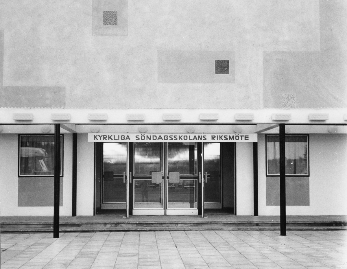 Entrén vid Folkets Park i Linköping. En skylt upphängd övanför ingången där det står "KYRKLIGA SÖNDAGSSKOLANS RIKSMÖTE".