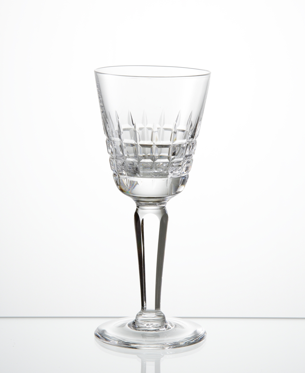 Design: Ingeborg Lundin.
Sherryglas med tulpanformad kupa med skärslipat rutmönster på nedre delen av kupan. Fasettslipat balusterben på slät fot.