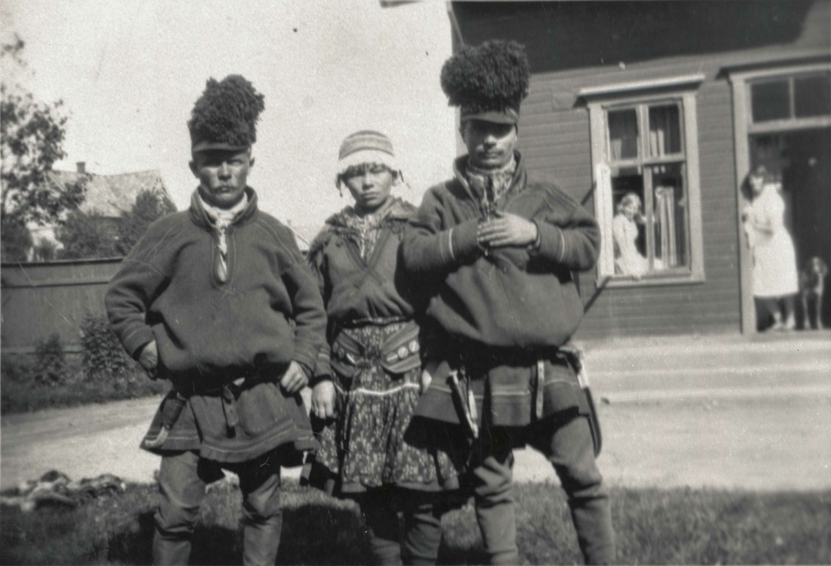 Tre personer i samisk drakt, fotografert på gårdsplassen ved Harstad sykehus.