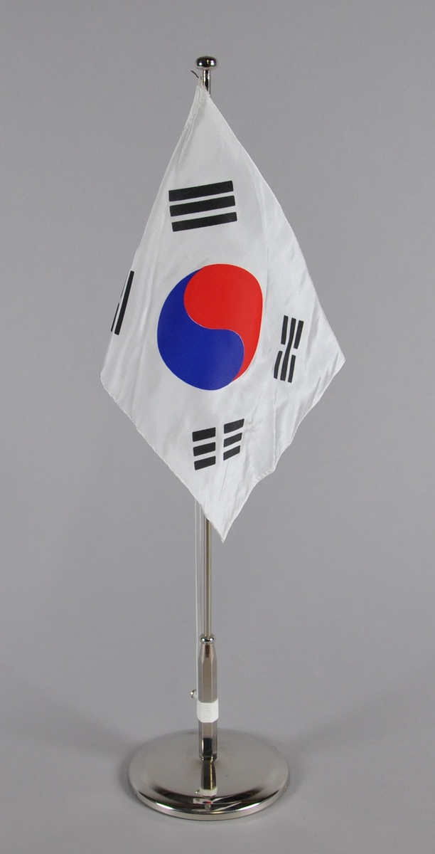 Bordflagg på stang fra Sør-Korea. Hvitt flagg med yin-yang symbol i rødt og blått.