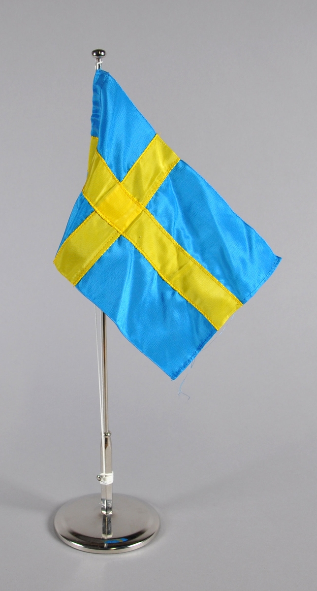 Bordflagg på stang fra Sverige. Blått flagg med gult kors.
