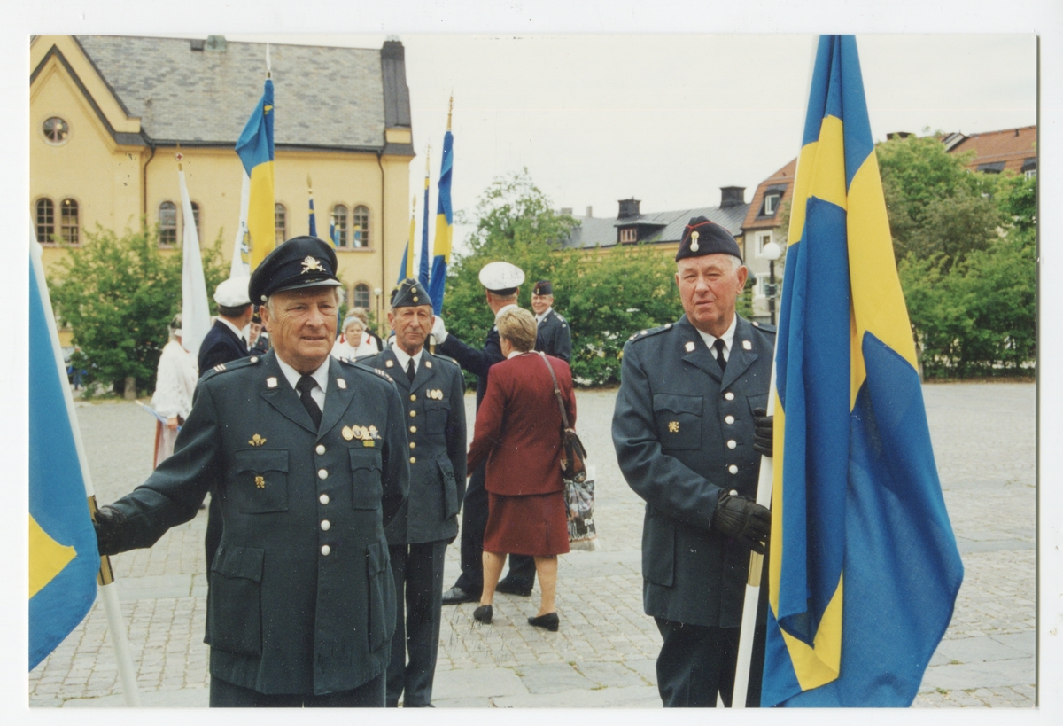 Officerare med svenska flaggor och civilklädda på borggården i Linköping.