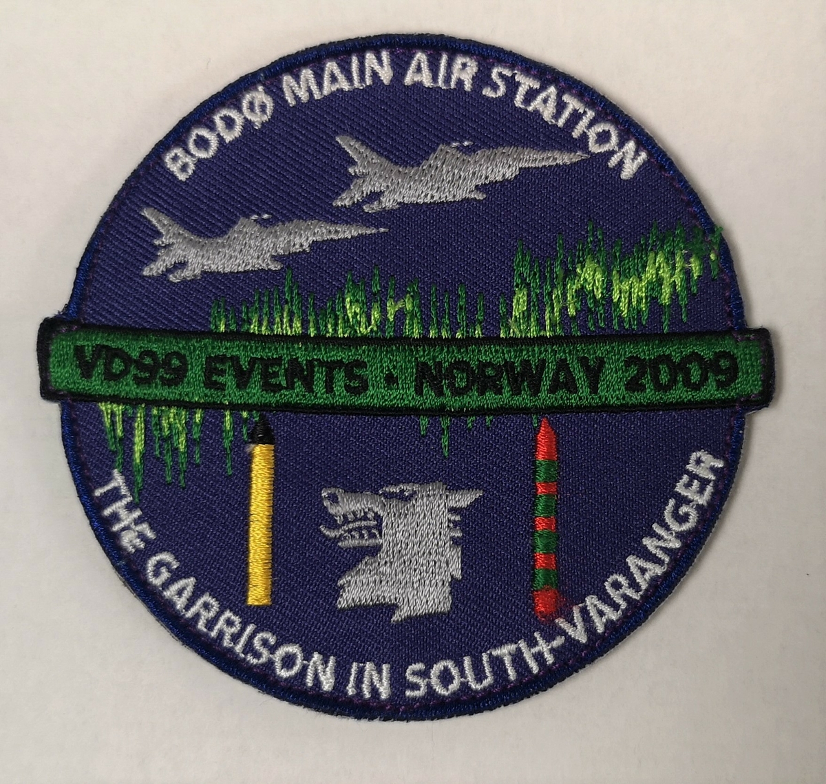 To F-16 og emblem til GSV på blå bakgrunn med nordlys.