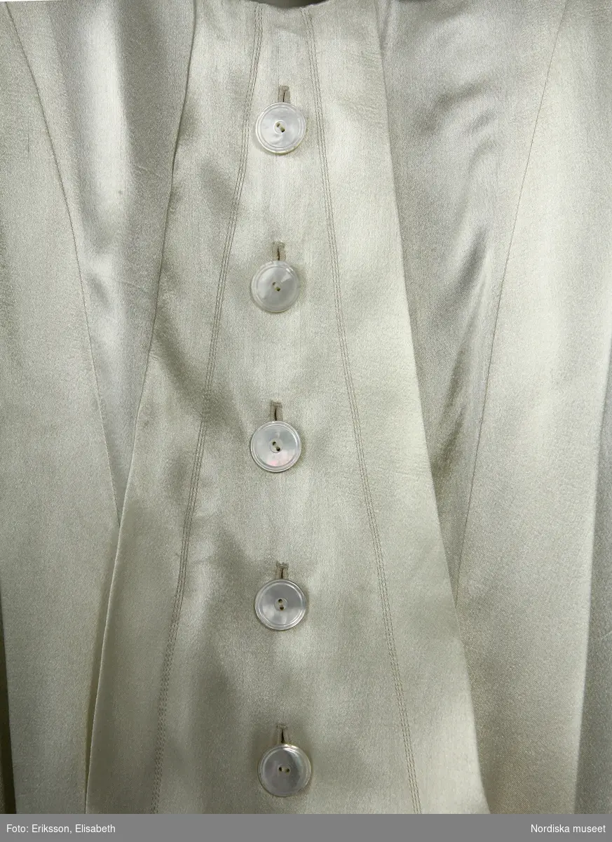 Ordered by Nanna Svartz (1890–1986), physician, Doctor of Medicine and Sweden’s first female professor at a state university in 1937.
Delivered June 1937. Silk tailcoat and long, slim skirt. Nanna Svartz wore the jacket with a cream silk pussy-bow blouse with mother of pearl buttons. Her monocle (eyeglass) was kept in the breast pocket. At her ceremonial installation she also wore the traditional doctor’s hat. The emblem of the medical profession is embroidered in silk on the velvet collar.