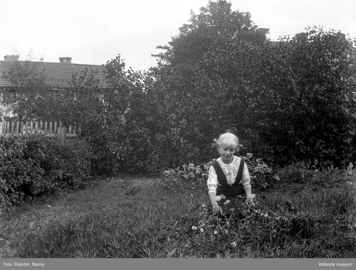 Troligtvis Anna Karin Zackrisson i trädgården vid fotoateljén på Mogärde. Anna Karin var dotter till fotografen Nannys syster Amy.