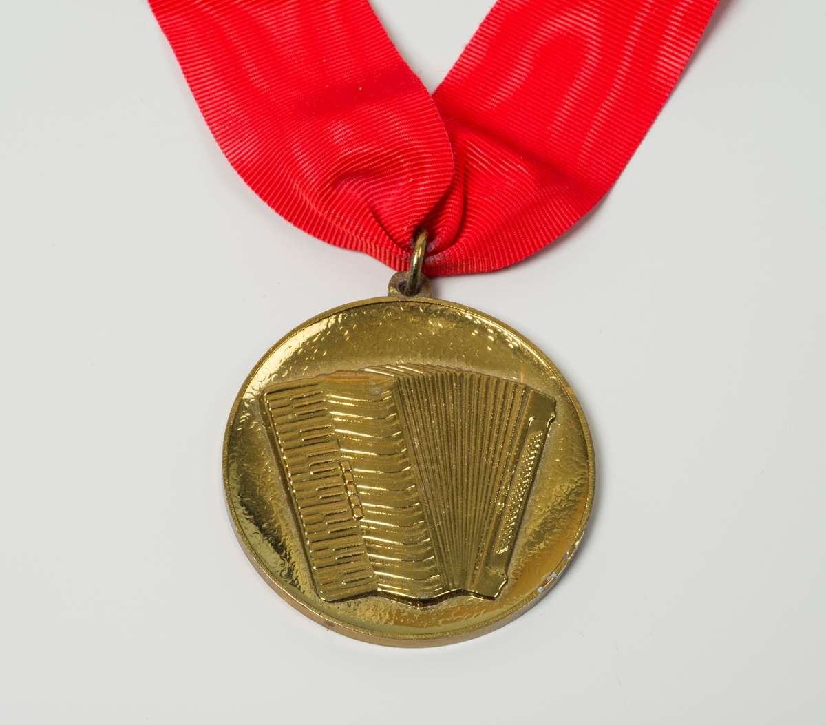 Oslo Trekkspillklubb. Medalje i gullfarge med rød sløyfe. Trekkspill som motiv på fremsiden.
