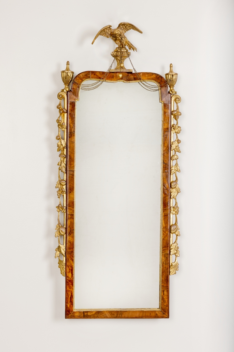 Rektangulært, høyreist speil med 2 speilplater, brun treramme omkranset av forgylt akantus på sidene og ørn med messinglenker sentrert på ovesiden. Treplater på baksiden.
