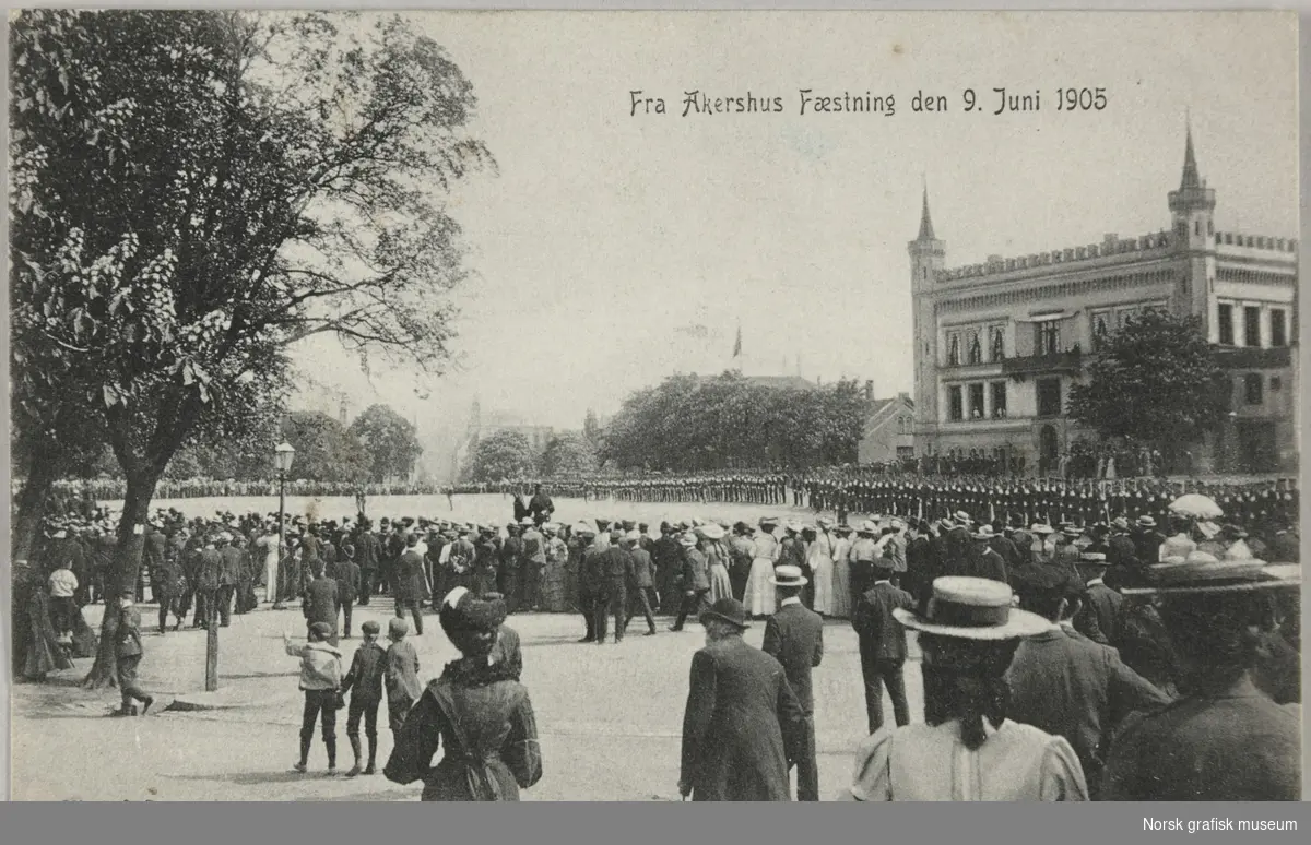 Postkort med bilde av folk som er samlet ved Akershus Festning 9. juni 1905, to dager etter unionsoppløsningen. Soldater, antageligvis H. M. Kongens Garde er samlet foran festningen.