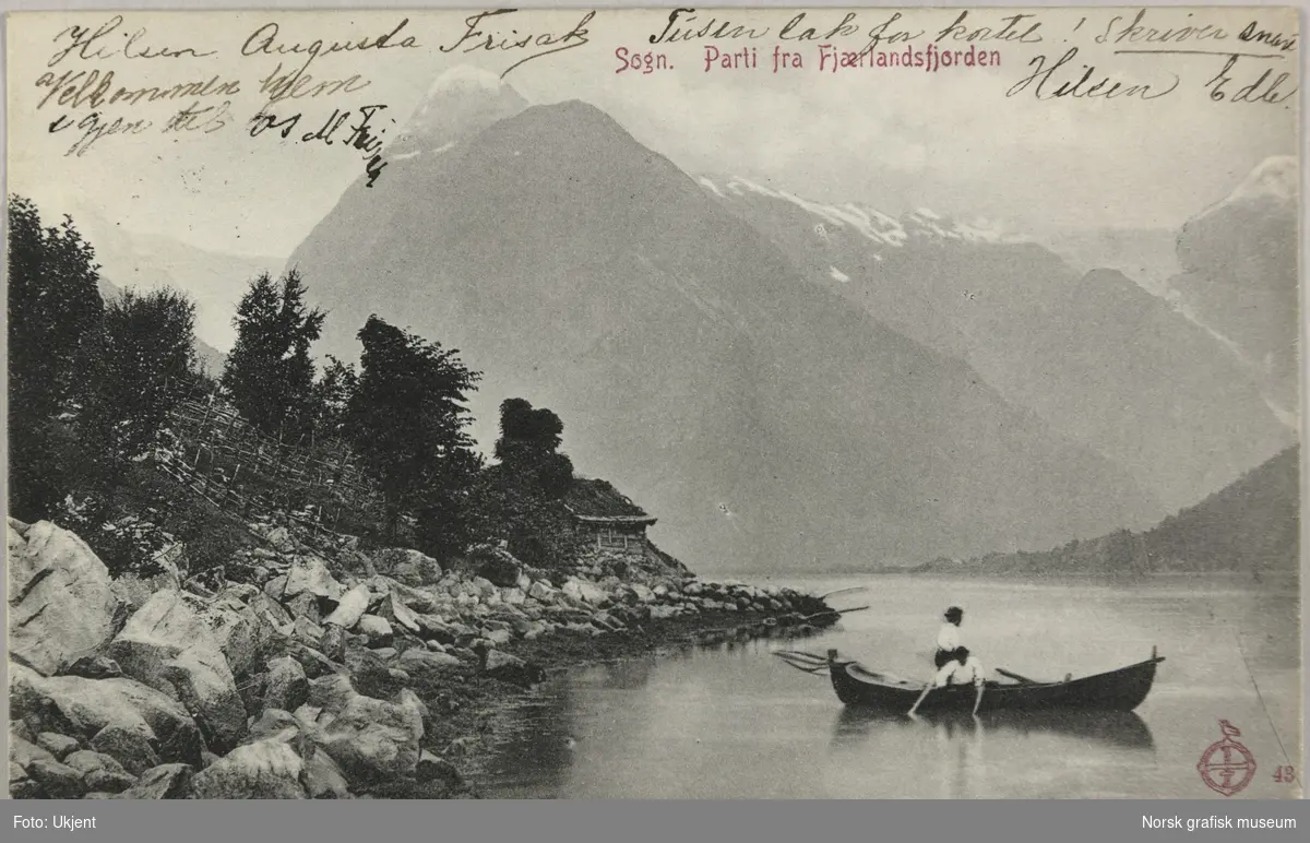 Postkort til Olava Lunde med bilde fra Fjærlandsfjorden i Sogn. Det er to personer i en robåt med bratte fjell og ei bre i bakgrunnen.