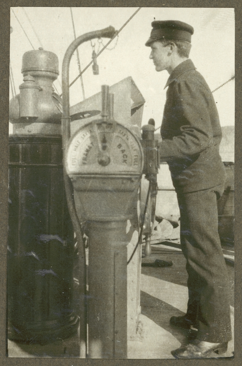 Bilden visar en sjöman står vid rodern på Fylgia och styr fartyget.