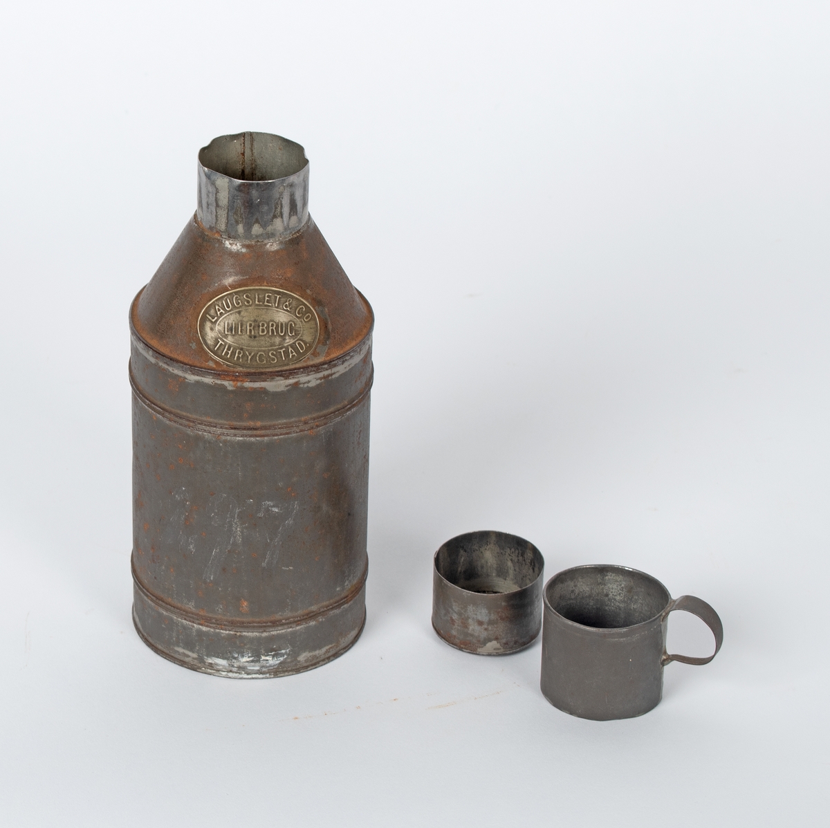 Metallflaske med to lokk; et tettsittende innerst og et ytterst med liten hank.