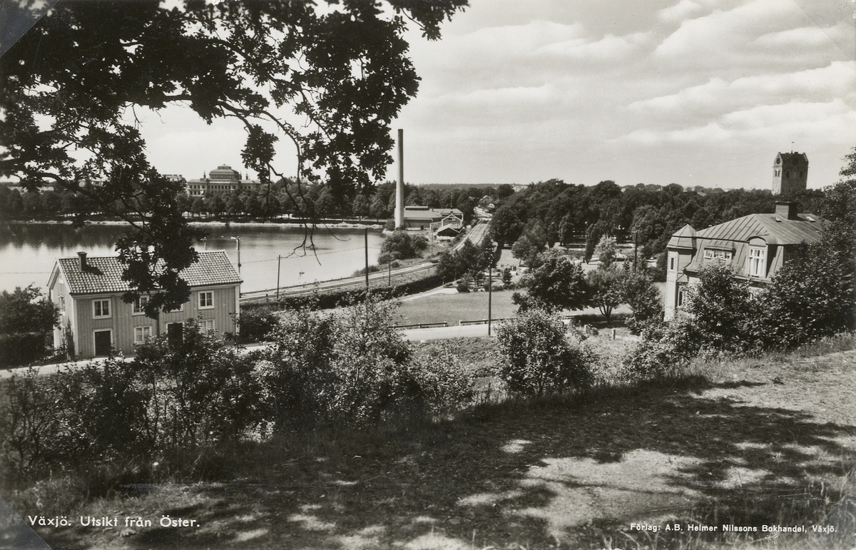 Växjö. Utsikt från Öster, 1939. Man ser Växjö läroverk, järnvägen och dåv. elverket utmed Växjösjön.
Till höger syns också tornet på domkyrkan, över konstnären Gustaf Sjöös villa.