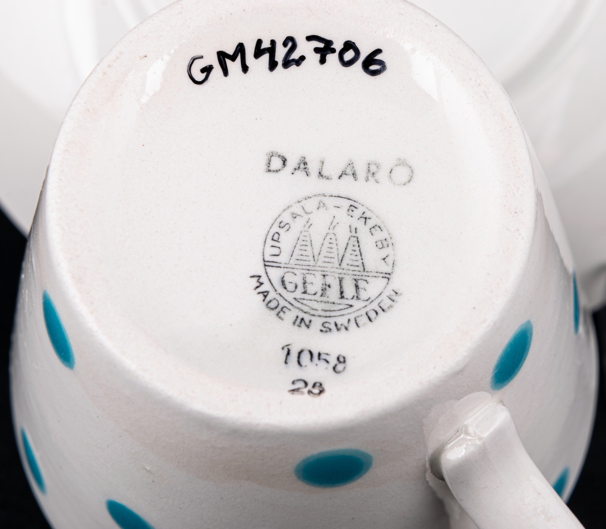 Kaffegods i flintgods, modell AU, dekor Dalarö från 1957 ritad av Eugen Trost; turkosa glest spridda prickar på koppen, turkos rand på fatets kant.