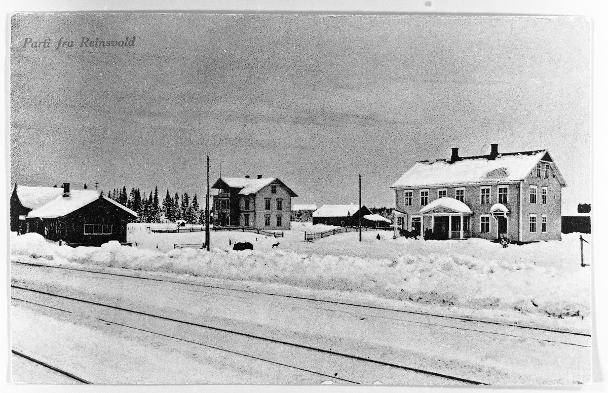 Reinsvoll, Vestre Toten, ca 1915. Avfotografert postkort som til venstre viser en del av jernbanestasjonen. Så kommer Bergerkafeen, og til høyre har vi L.O.Berges forretningsgård.